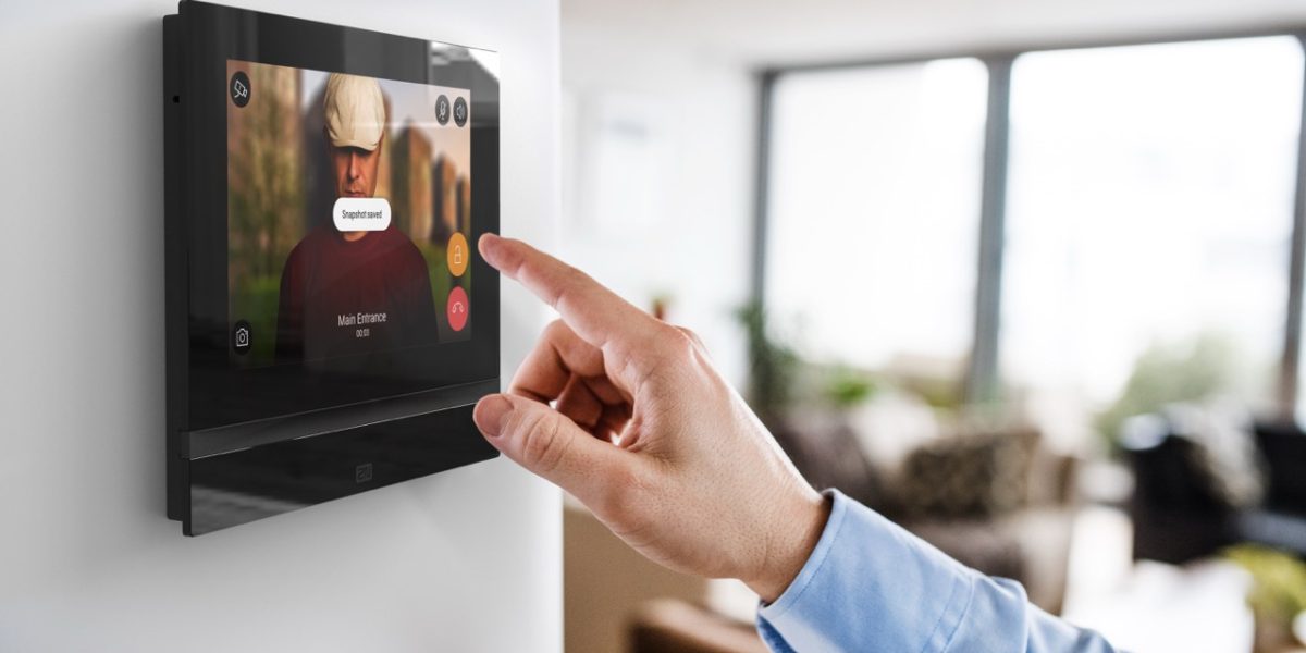 An unrecognizable man pointing to a tablet with smart home control system.